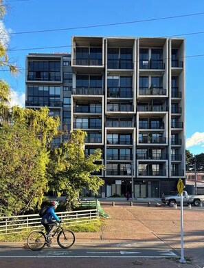 A multi-story building with a modern architectural style, featuring a series of balconies and large windows. - Modern & Cozy Apartment in North Bogotá (Bogotá)