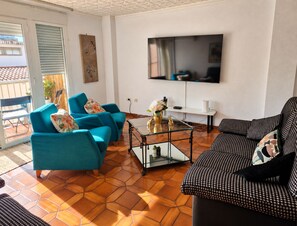 A living room with a sofa, a coffee table, and a TV mounted on the wall. - 🏖️ Spacious 4-bedroom apartment just a short walk from the beach. ☀️ (Vinaròs)