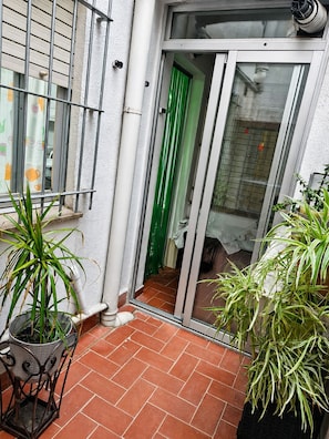 A small patio area with a sliding glass door leading to a room, a metal railing, and potted plants. - 🏖️ Spacious 4-bedroom apartment just a short walk from the beach. ☀️ (Vinaròs)