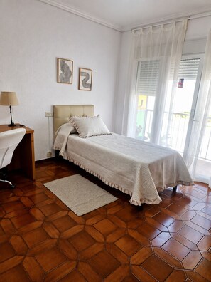 A bedroom with a bed, a desk, and a window with curtains. - 🏖️ Spacious 4-bedroom apartment just a short walk from the beach. ☀️ (Vinaròs)