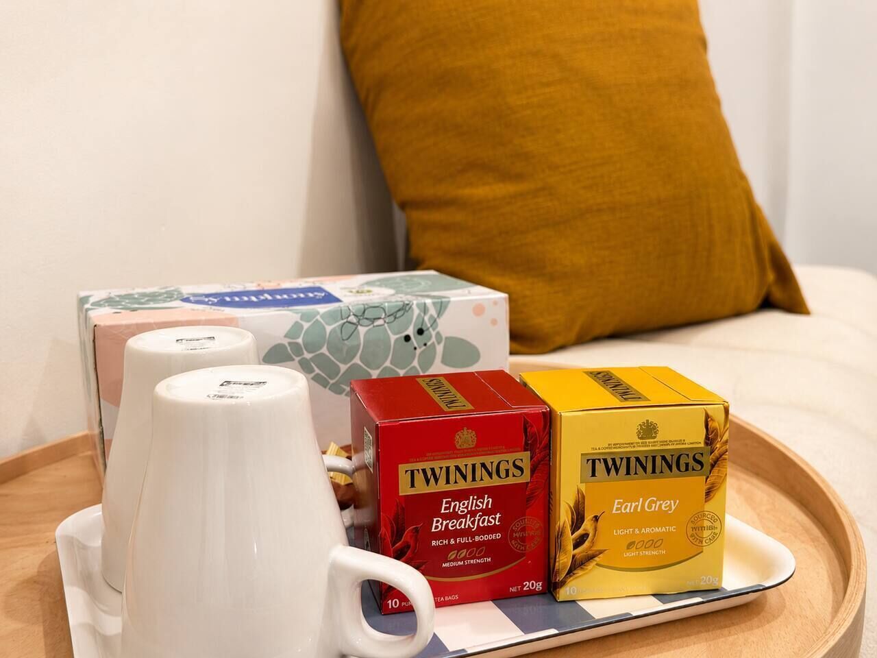A tray with two Twinings English Breakfast tea boxes, a white mug, and a white teapot.