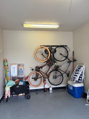 A garage with bicycles mounted on a wall, a cleaning cart, and a cooler. - Rest Ashored- 2 mins from the beach, dog friendly (Long Beach)