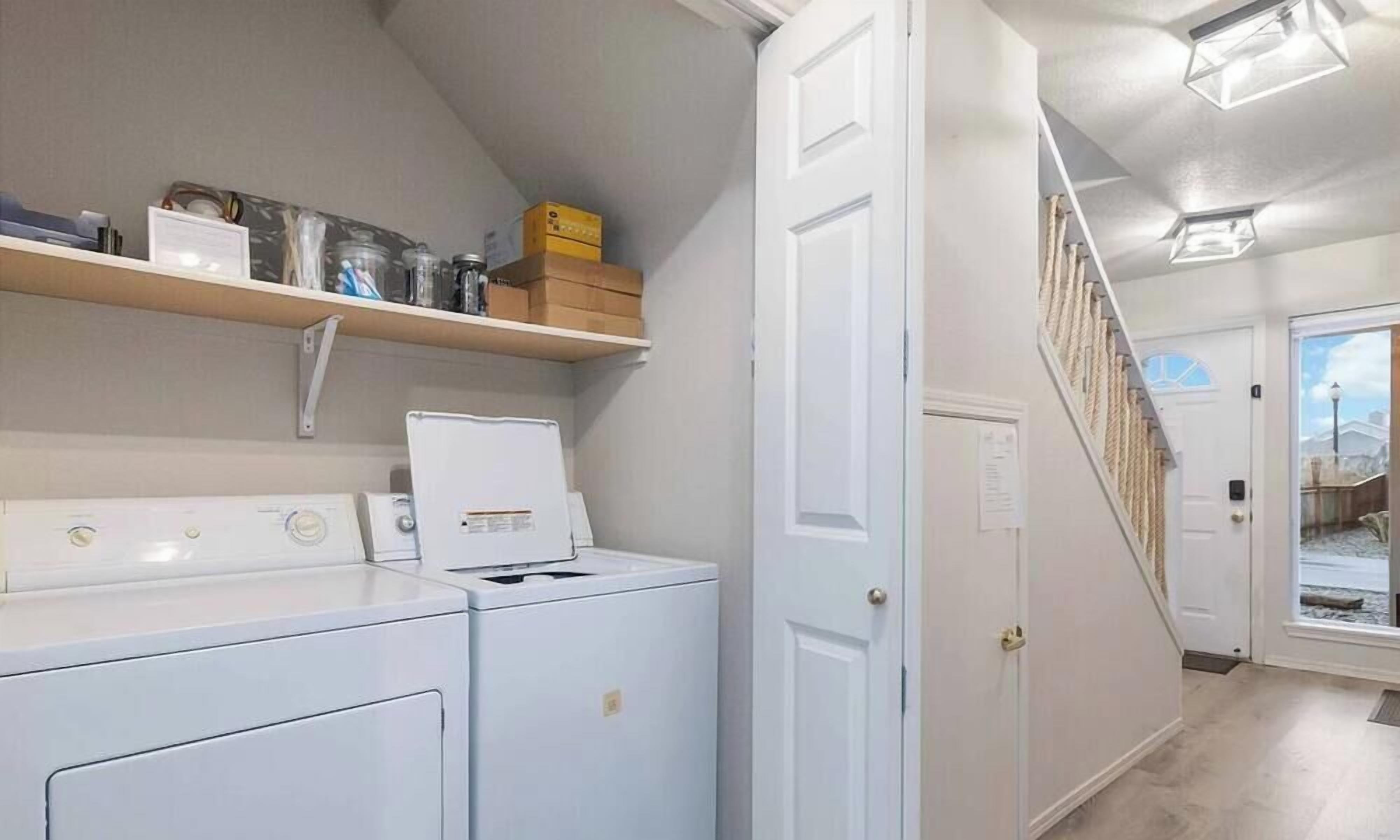 A laundry area with stacked boxes, a dryer, and a washing machine.