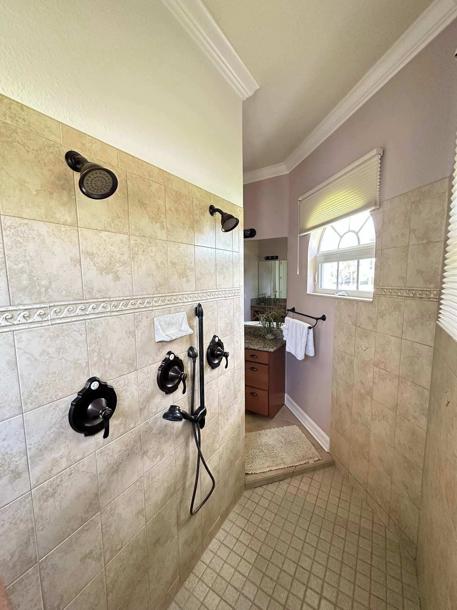 A bathroom with a shower, a sink, and a mirror.