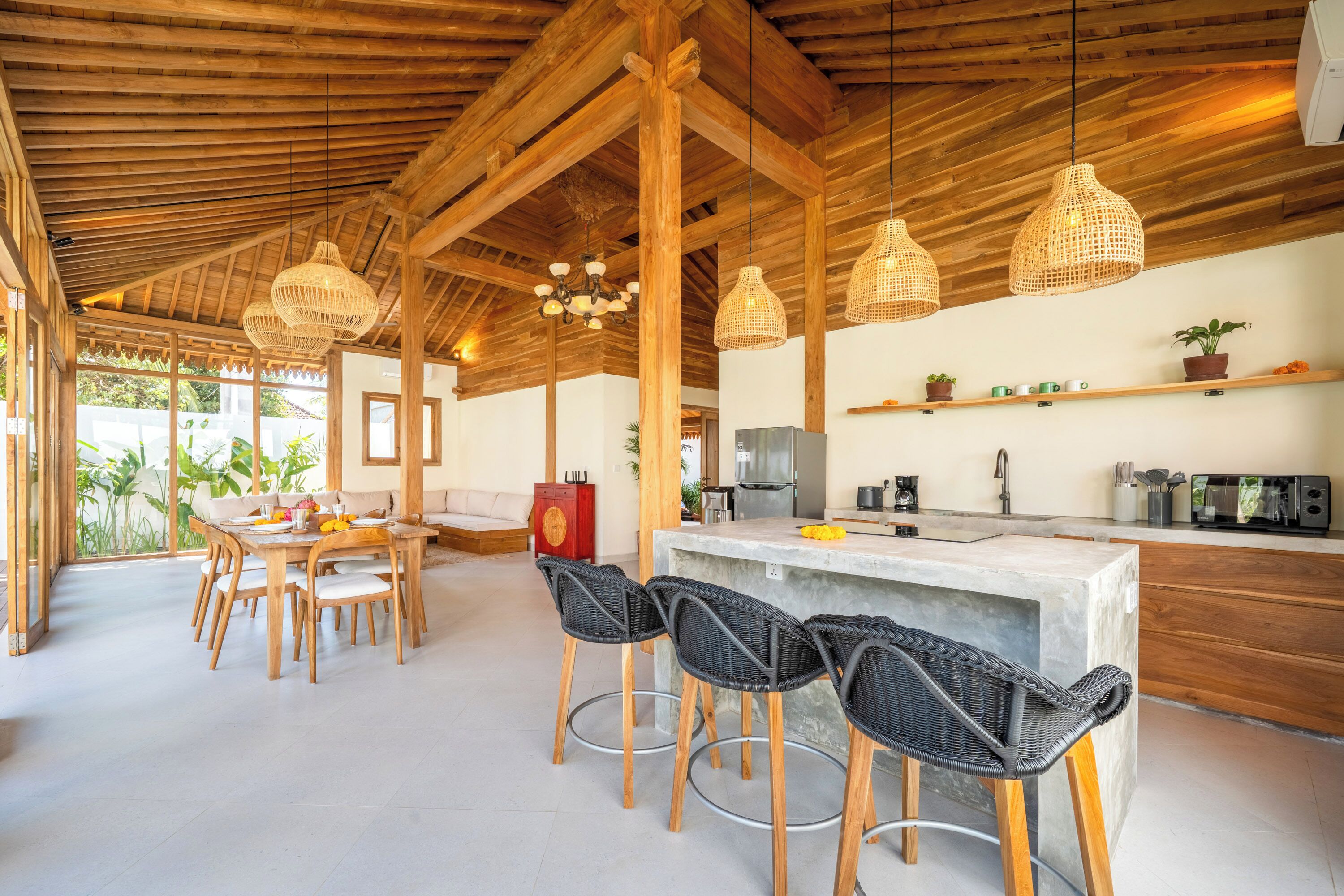 A spacious kitchen with a bar area, wooden ceiling beams, and modern appliances.