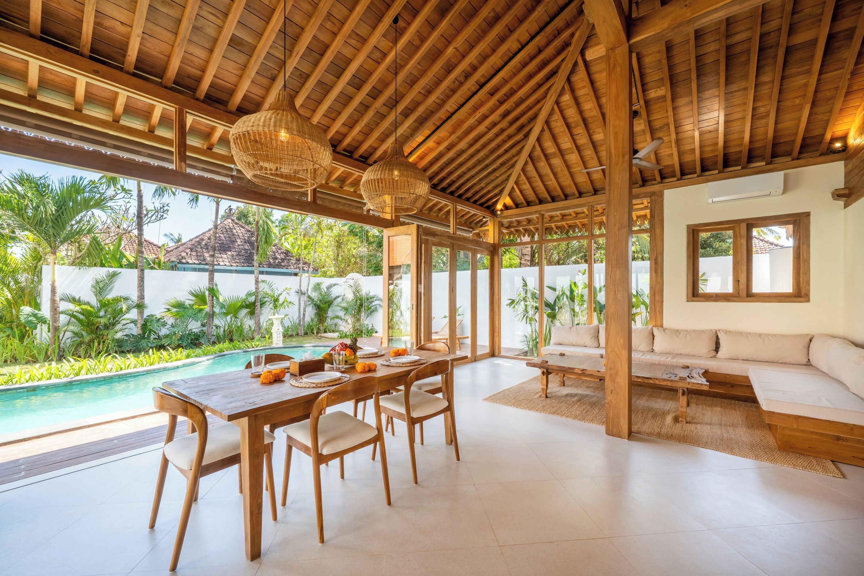 A spacious indoor area with a pool, wooden furniture, and a view of the outdoors.