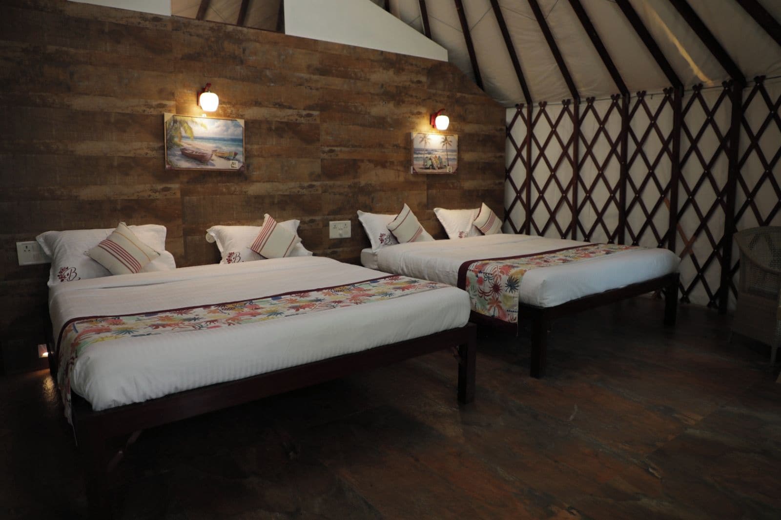 Una habitación con dos camas, paredes de madera y un separador de celosía.