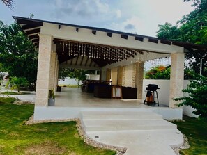 A covered outdoor area with a concrete floor, a grill, and a seating arrangement. - Spacious 4BR Retreat in El Limón  Mins to Waterfall & AC (El Limón)