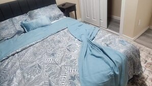 Un dormitori amb un llit, una tauleta de nit, un armari i una porta que dona a un bany.