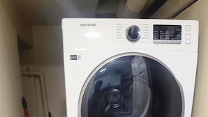 A stacked washer and dryer unit in a laundry room.