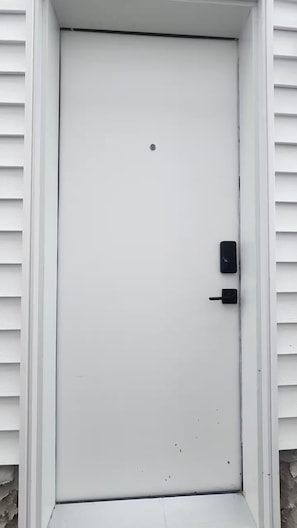 A white door with a black handle and a small lock.