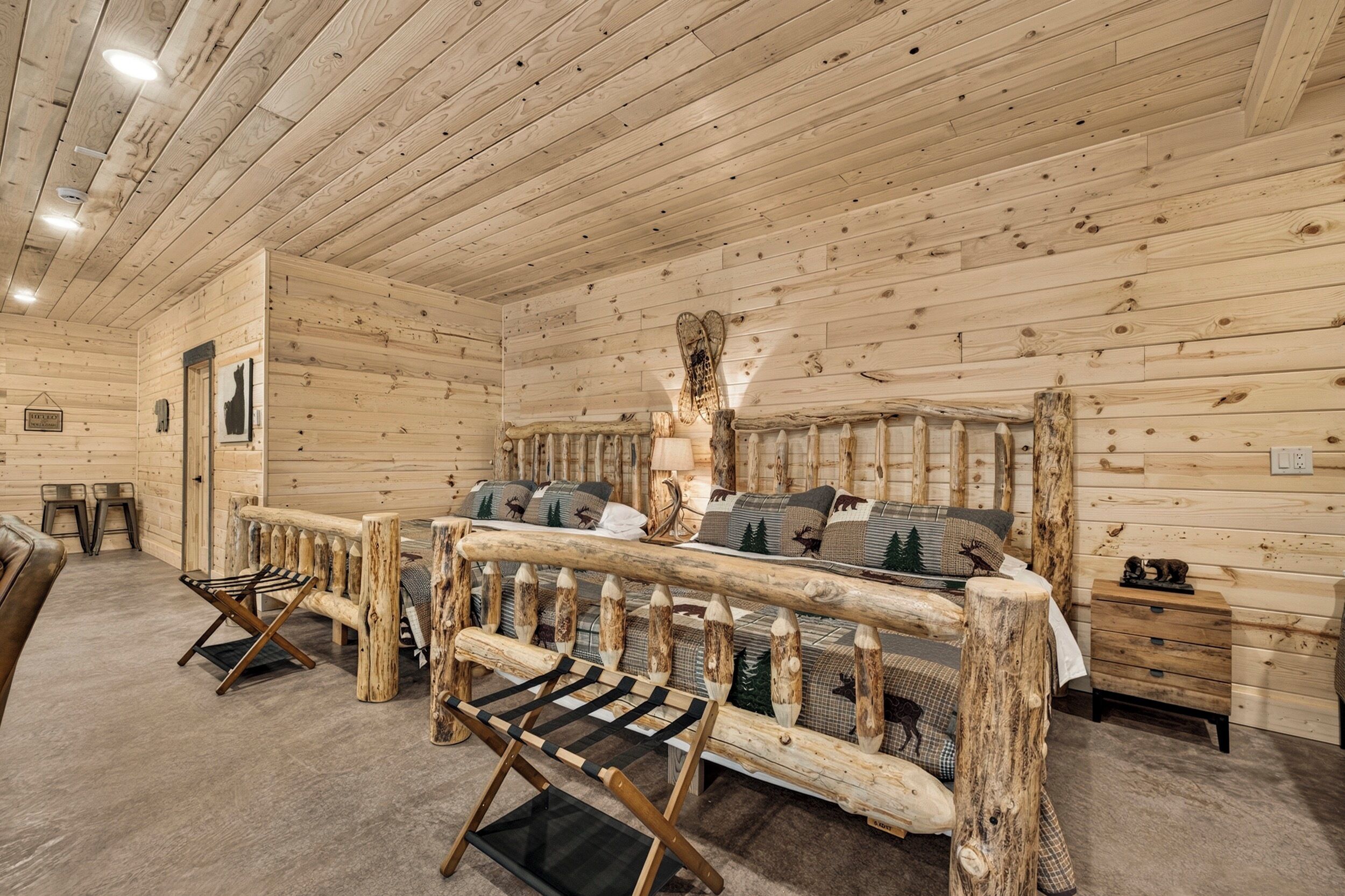 A log cabin interior with a bed, a bench, and a small table.
