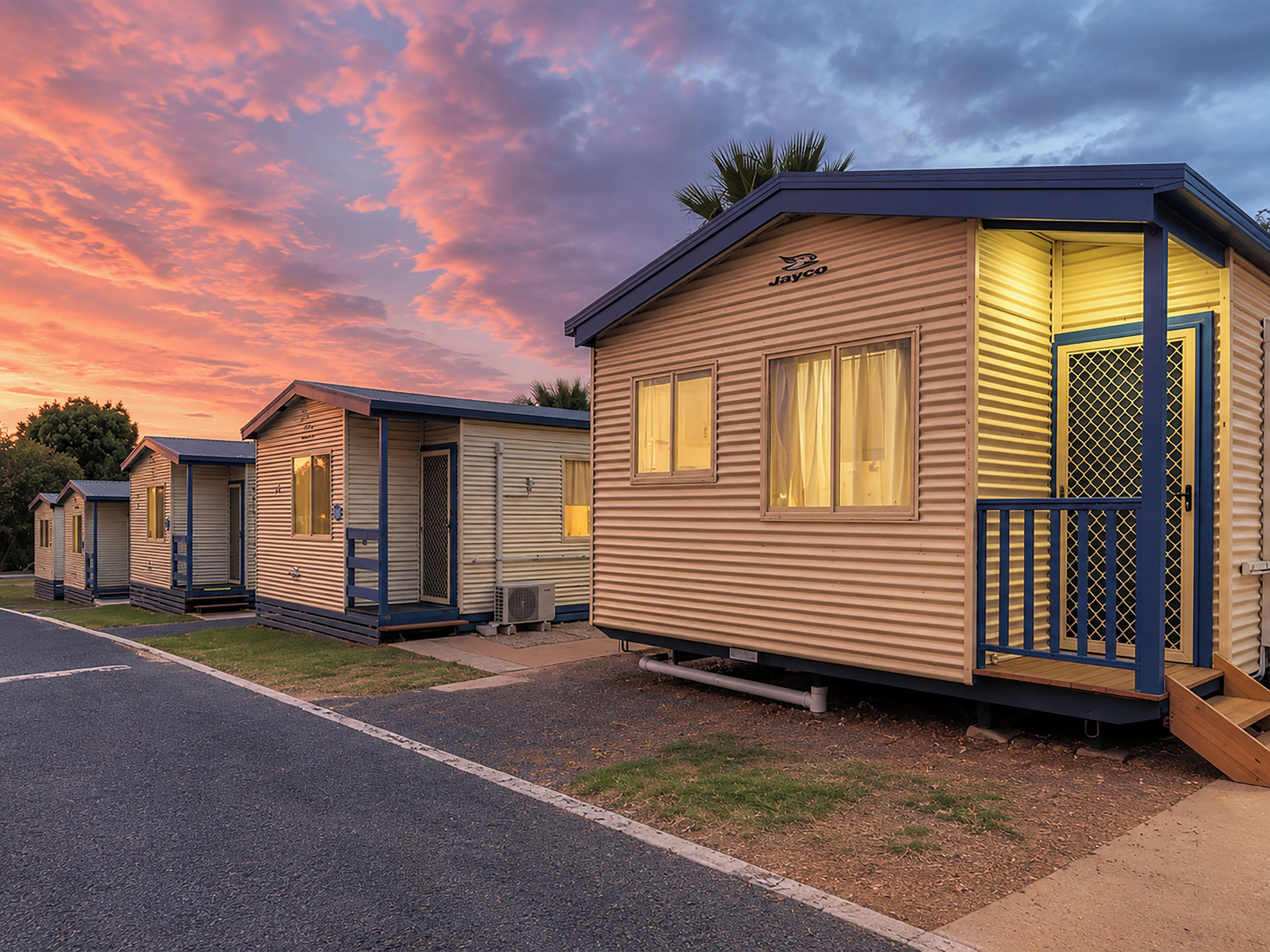A row of mobile homes with a flat roof, a front porch, and a small deck.