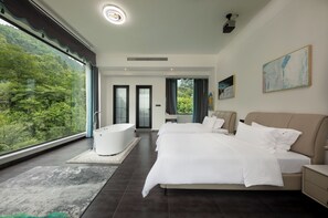 A modern bedroom with a large bed, a bathtub, and a view of a forest. - FLOWERS VALLEY (Zhangjiajie)
