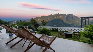 Un patio con dos sillones, una mesita y una planta en maceta.