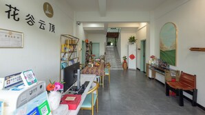 Un vestíbulo de hotel con una recepción, una escalera y un certificado enmarcado en la pared.