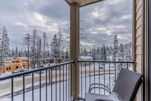 Ein Balkon mit Blick auf eine verschneite Landschaft und ein Gebäude in der Ferne.