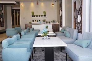 A hotel lobby with seating arrangements, a reception desk, and decorative wall elements. - Clowzer Al Rabea (Riyadh)