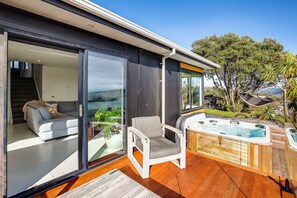 A modern house with a sliding glass door leading to a living area with a sofa and a chair.