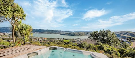 A hot tub with a view of a lake and a town in the background.