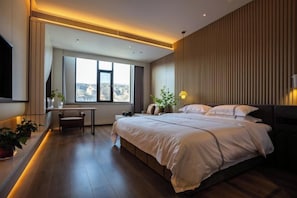 Una habitación de hotel moderna con una cama grande, un escritorio y vistas a la ciudad.