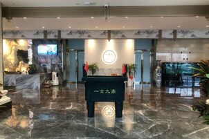 Un hall con una recepción, una pantalla digital y una pared decorativa.