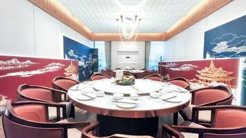 A conference room with a round table, chairs, and a ceiling light fixture.