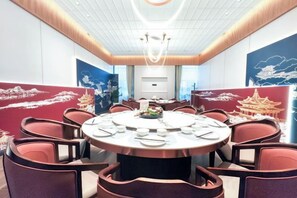 A conference room with a round table, chairs, and a ceiling light fixture. - Jizhou Hotel (Ji County)