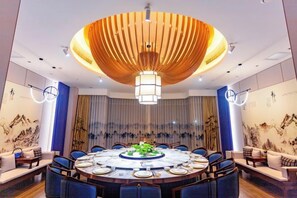 A conference room with a round table, chairs, and a central floral arrangement. - Jizhou Hotel (Ji County)
