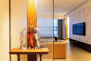 A modern interior with a wooden table, a television mounted on the wall, and a seating area.