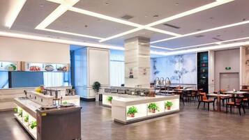 Un restaurante moderno con una barra central, zona de estar y vistas a la cocina.