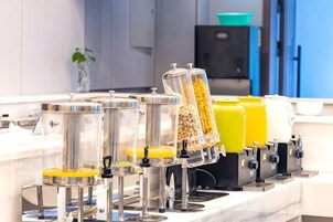 Una barra de desayuno con varios dispensadores para distintos alimentos.