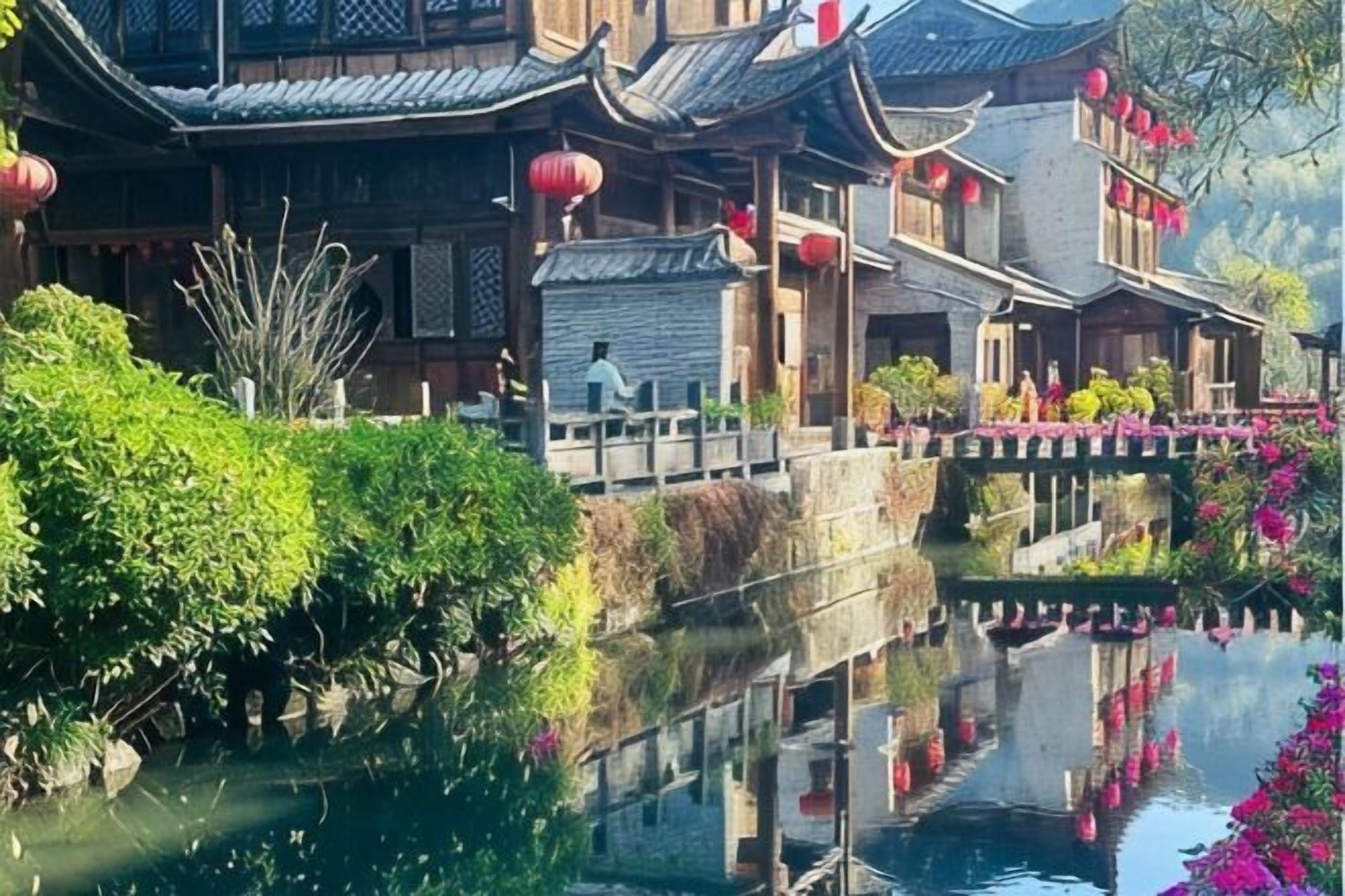 Un edificio tradicional con su reflejo en el agua, un puente y un sendero.