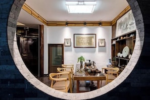 A dining area with a round table, chairs, and a ceiling light fixture.