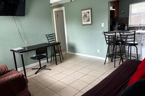 A compact living space with a dining area, kitchenette, and a TV mounted on the wall. - Downtown Sarasota 2BR Apartment 2BA Pet Friendly Beaches Sleeps 5 (Sarasota)