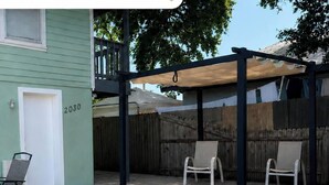 A covered patio area with two chairs and a table, a wooden fence, and a house number 2030. - Downtown Sarasota 2BR Apartment 2BA Pet Friendly Beaches Sleeps 5 (Sarasota)