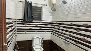 A bathroom with a toilet, a sink, and a shower. - Hotel Bindusagar (Bhubaneswar)