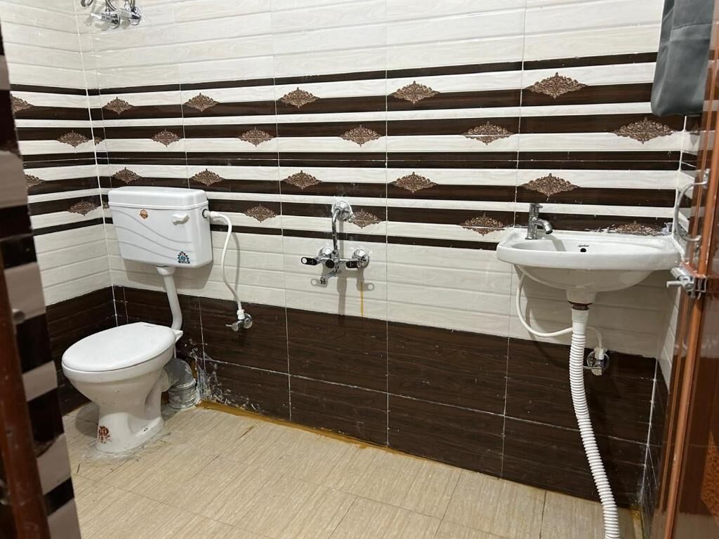 A bathroom with a toilet, sink, and shower.
