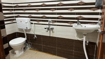 A bathroom with a toilet, sink, and shower.
