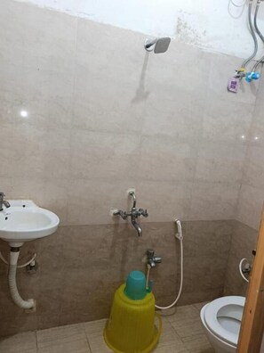 A bathroom with a sink, shower, and toilet. - Hotel Bindusagar (Bhubaneshwar)