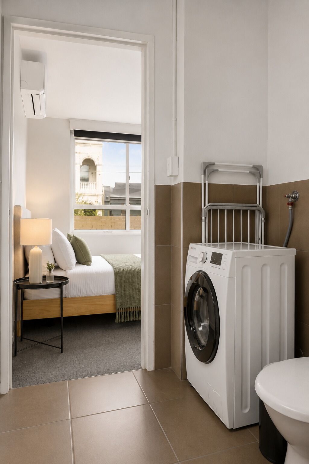 Une buanderie équipée d’un lave-linge, d’un radiateur et de toilettes.