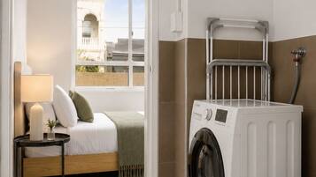 Une buanderie équipée d’un lave-linge, d’un radiateur et de toilettes.