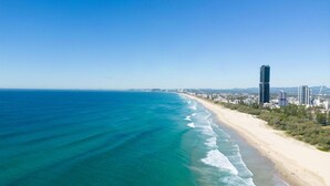 A coastal cityscape with a beach, clear blue sky, and high-rise buildings. - Tranquil Waterfront Retreat | Broadbeach Waters (Broadbeach Waters)