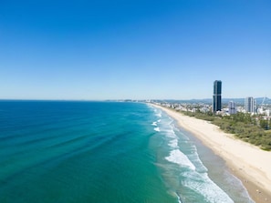 Eine Küstenstadt mit Strand, blauem Himmel und hohen Gebäuden.