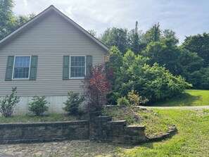 A house with a gabled roof, a front window with shutters, and a brick retaining wall. - Welcome to Sherwood Forest in the heart of Ohio! (Newark)