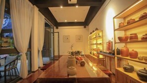 A traditional Japanese-style room with tatami flooring, a low table, and a shelf with pottery. - Huiyuanlou Inn (Jianshui Ancient City Zhujia Garden Branch) (Jianshui)