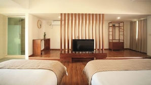 A hotel room with a TV, two beds, a wooden panel wall, and a sliding door closet. - Huiyuanlou Inn (Jianshui Ancient City Zhujia Garden Branch) (Jianshui)