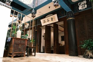 A traditional interior with a signboard, wooden furniture, and columns. - Huiyuanlou Inn (Jianshui Ancient City Zhujia Garden Branch) (Jianshui)