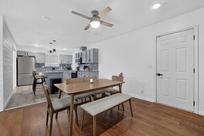 Eine moderne Küche mit Essbereich, Holzboden und Deckenventilator.