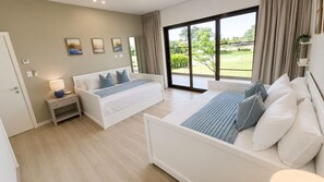 A modern bedroom with a large bed, a sofa, a bedside table, and a view of the outdoors. - Coral Juliette •Luxury PH in Cocotal • Pool • BBQ (Punta Cana)